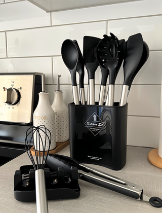 Black utensil set beside a stove