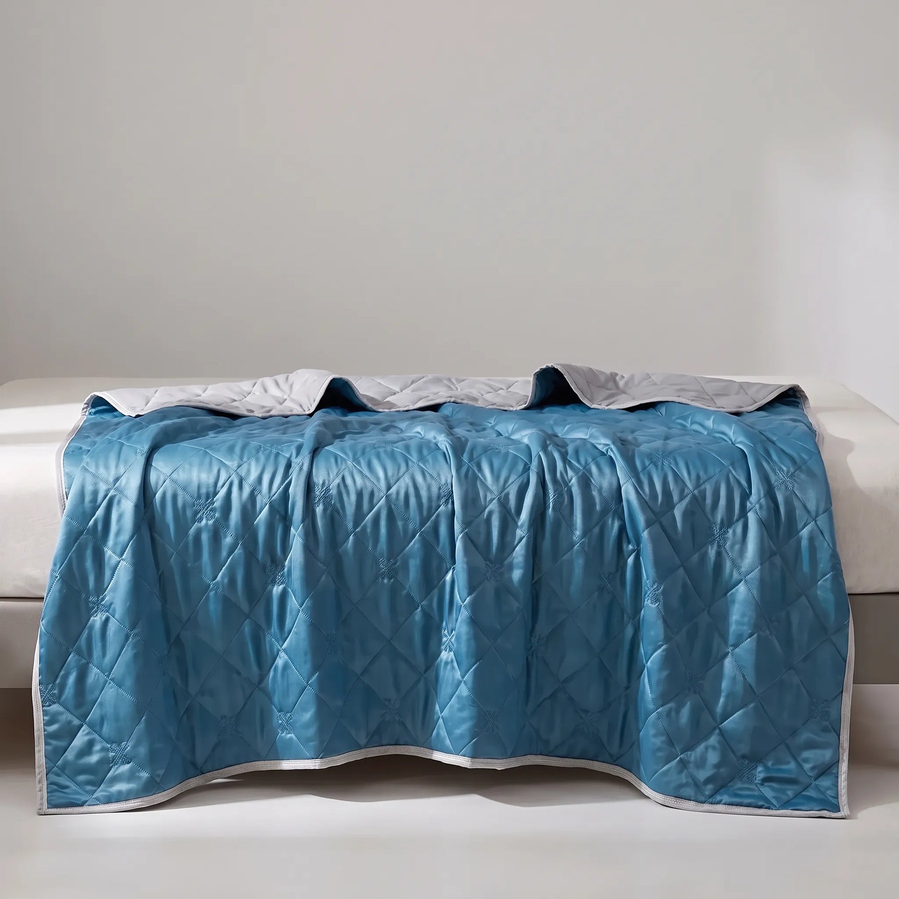 Dark Blue quilted summer blanket draped across a bed