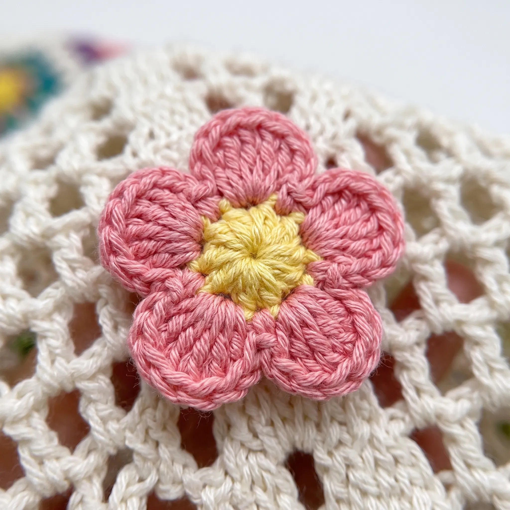 Close view of a crocheted flower on the tote bag