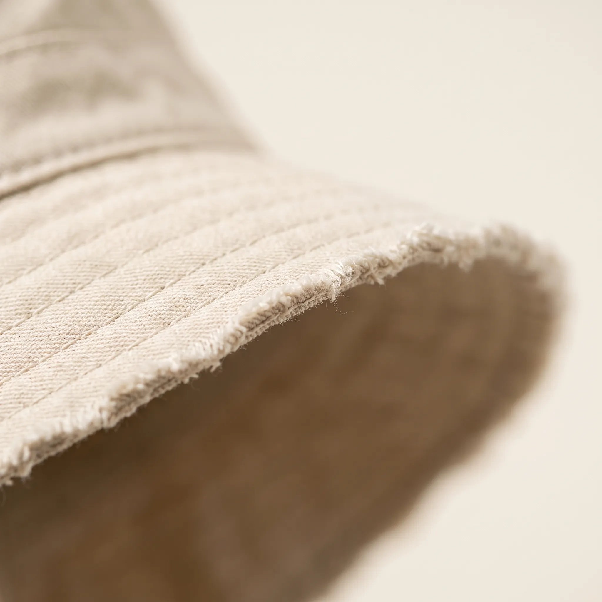 Close view of the stitched crown and frayed brim edge