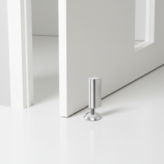 Silver magnetic door stop mounted on a light floor
