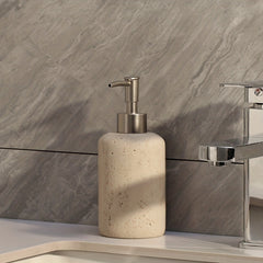 Speckled soap dispenser beside a chrome faucet