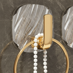 Close view of a gold-tone hook on a clear backplate