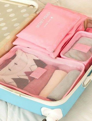 Pink packing organizer set arranged inside a suitcase