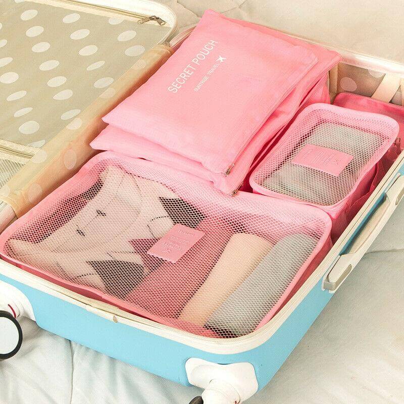 Pink packing organizer set arranged inside a suitcase