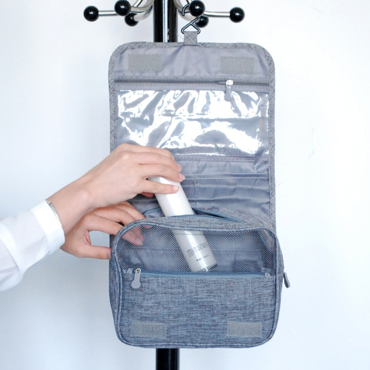 Gray toiletry organizer hanging from its integrated hook