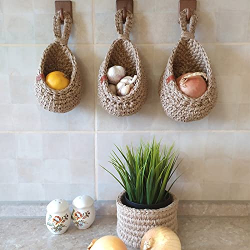 Three hanging cotton storage baskets arranged on a tiled wall
