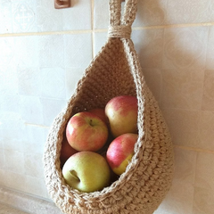 Single hanging cotton basket holding apples