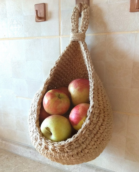 Single hanging cotton basket holding apples