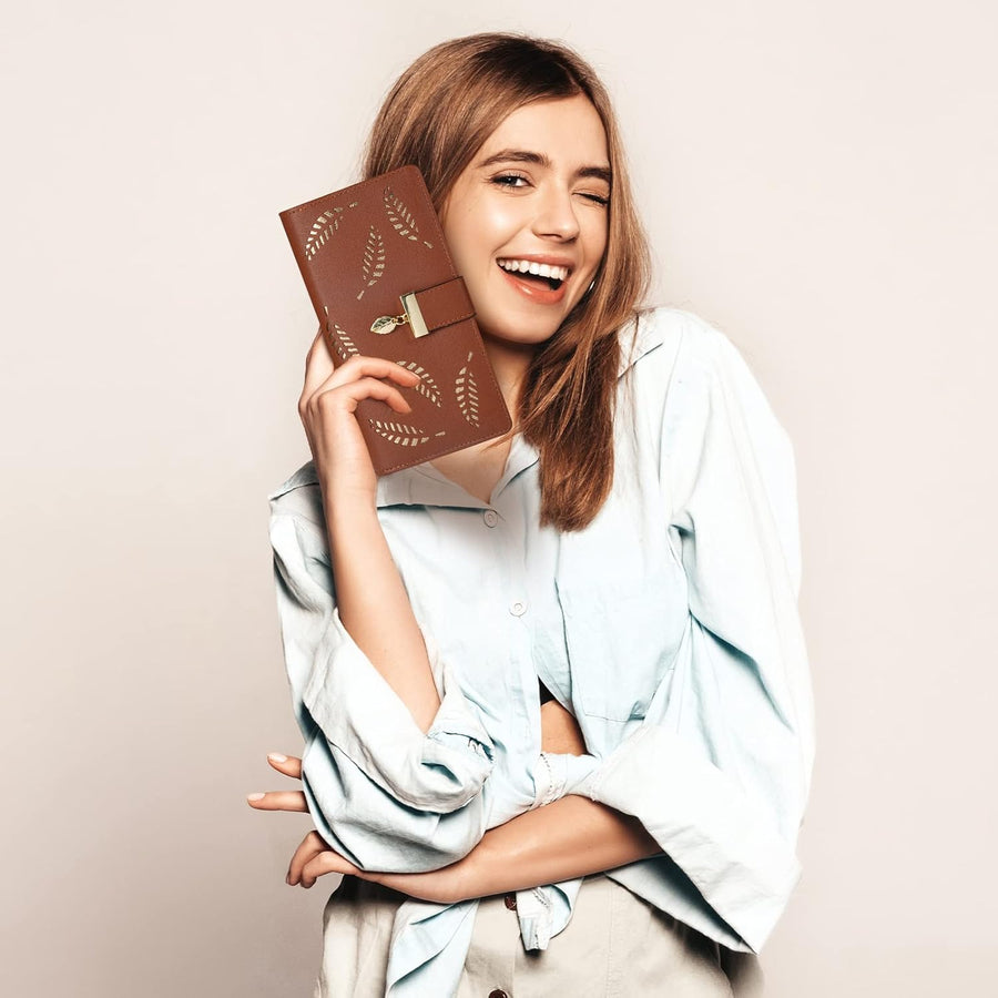 Brown leaf-cutout long wallet held beside the face