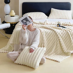 Cream plush ribbed blanket styled on a bed with matching pillow