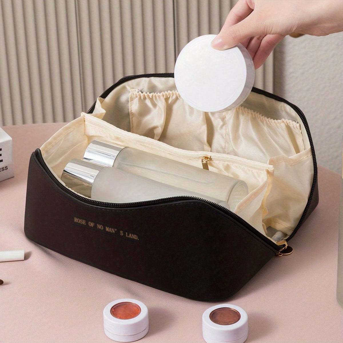 Black toiletry bag with cosmetics in its interior sections