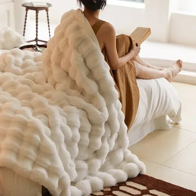 Light-neutral textured throw draped over a bed
