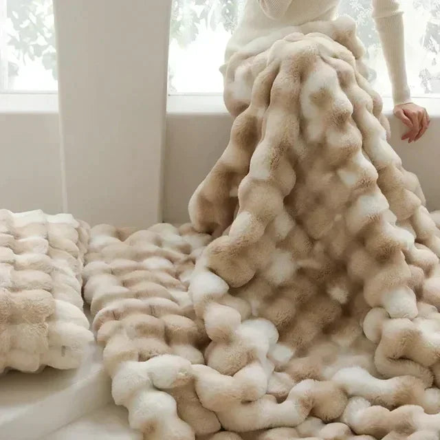 Raised rounded texture of the light-neutral faux-fur throw