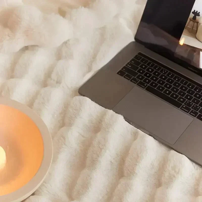 Light-neutral textured throw used across a desk