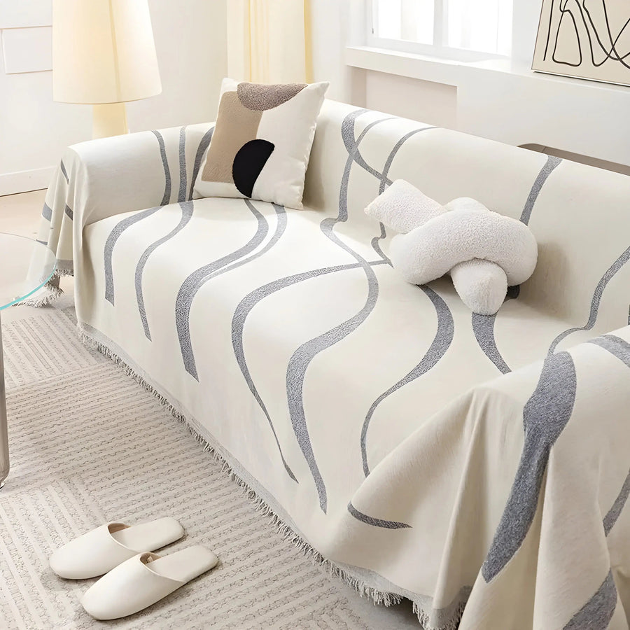 Gray reversible chenille-cotton throw draped over a sofa