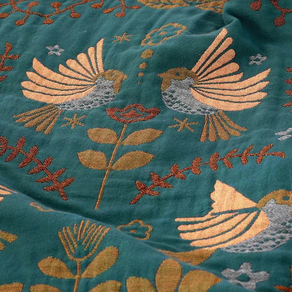 Close view of birds and flowers on the Turquoise woven throw