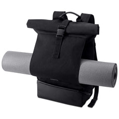 Black roll-top backpack carrying a rolled exercise mat