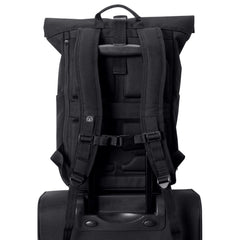 Black backpack attached to a suitcase trolley handle