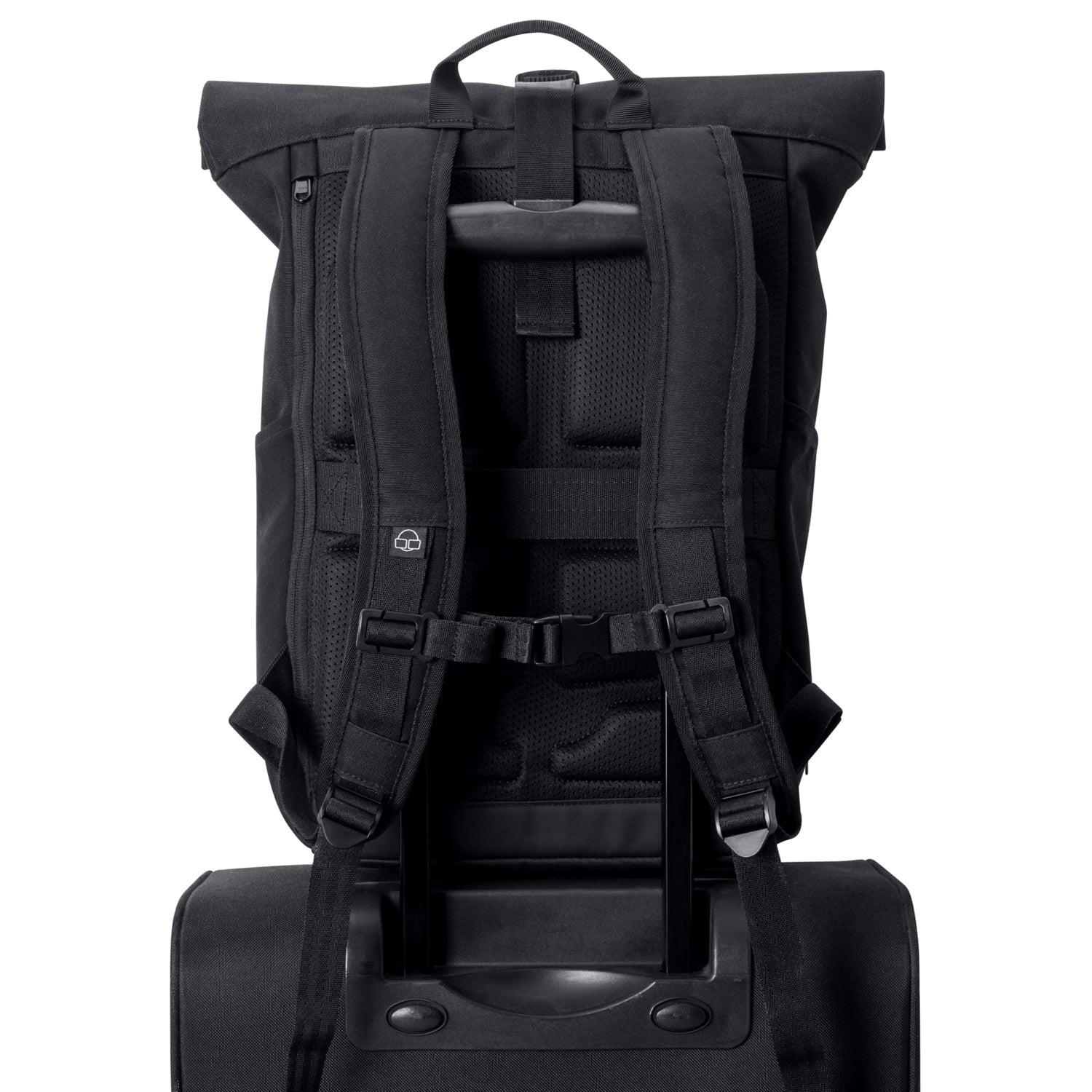 Black backpack attached to a suitcase trolley handle
