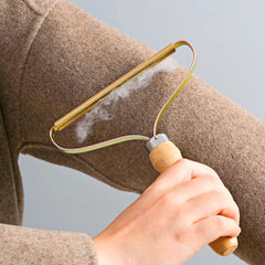 Portable lint remover used on a brown garment
