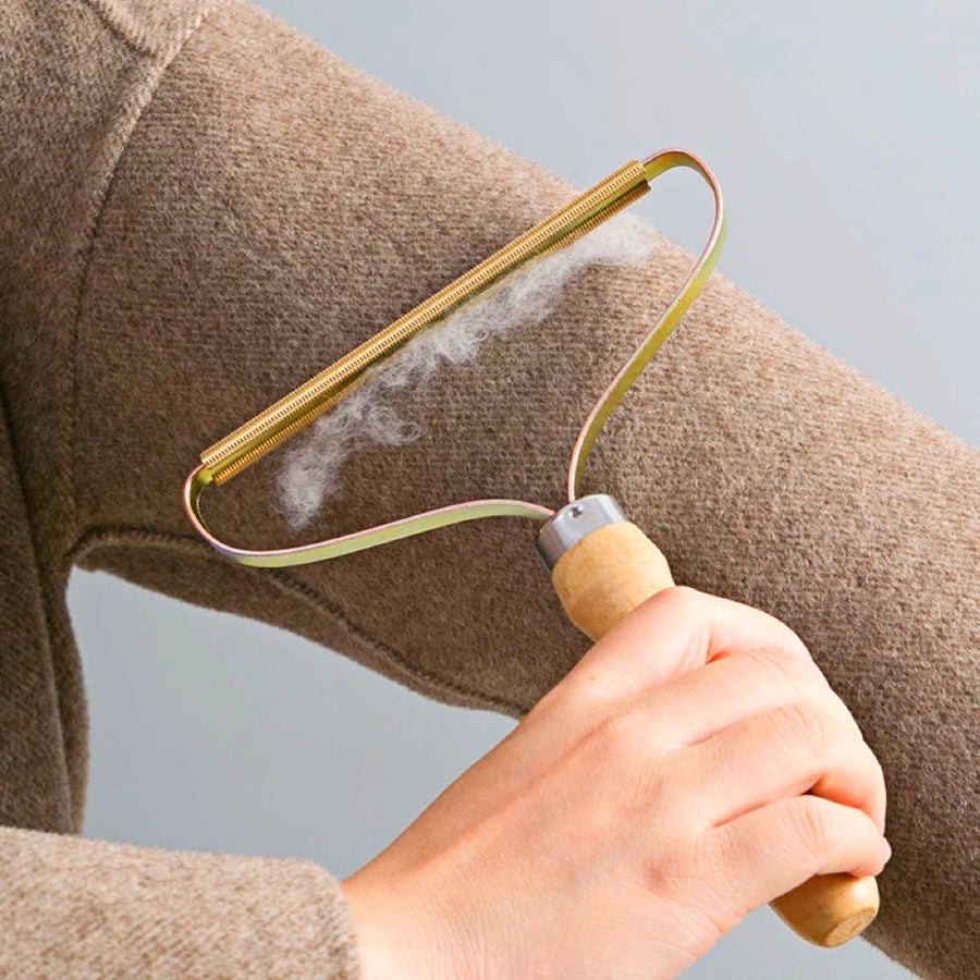 Portable lint remover used on a brown garment