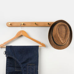 Beech wall coat rack holding a hanger and hat
