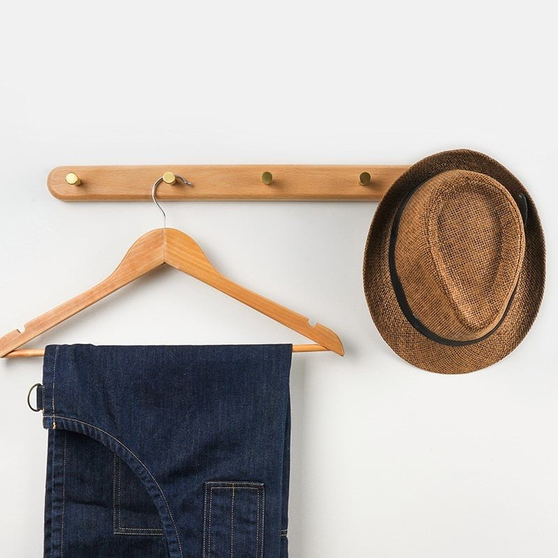 Beech wall coat rack holding a hanger and hat